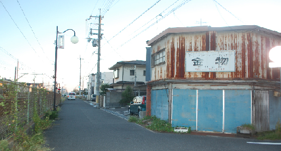 しばらく歩くと右手に金物屋さんが見えますが、もう少し先に歩いていきます。左側に踏切がありますが、3つ目の踏切を渡るとあと少しで右手に見えます！